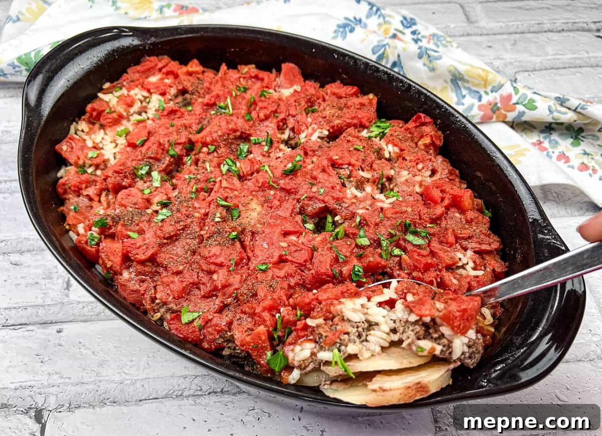 35 Classic Casserole Recipes That Have Everyone Coming Back 3 Shipwreck Casserole in a black dish with a spoon.