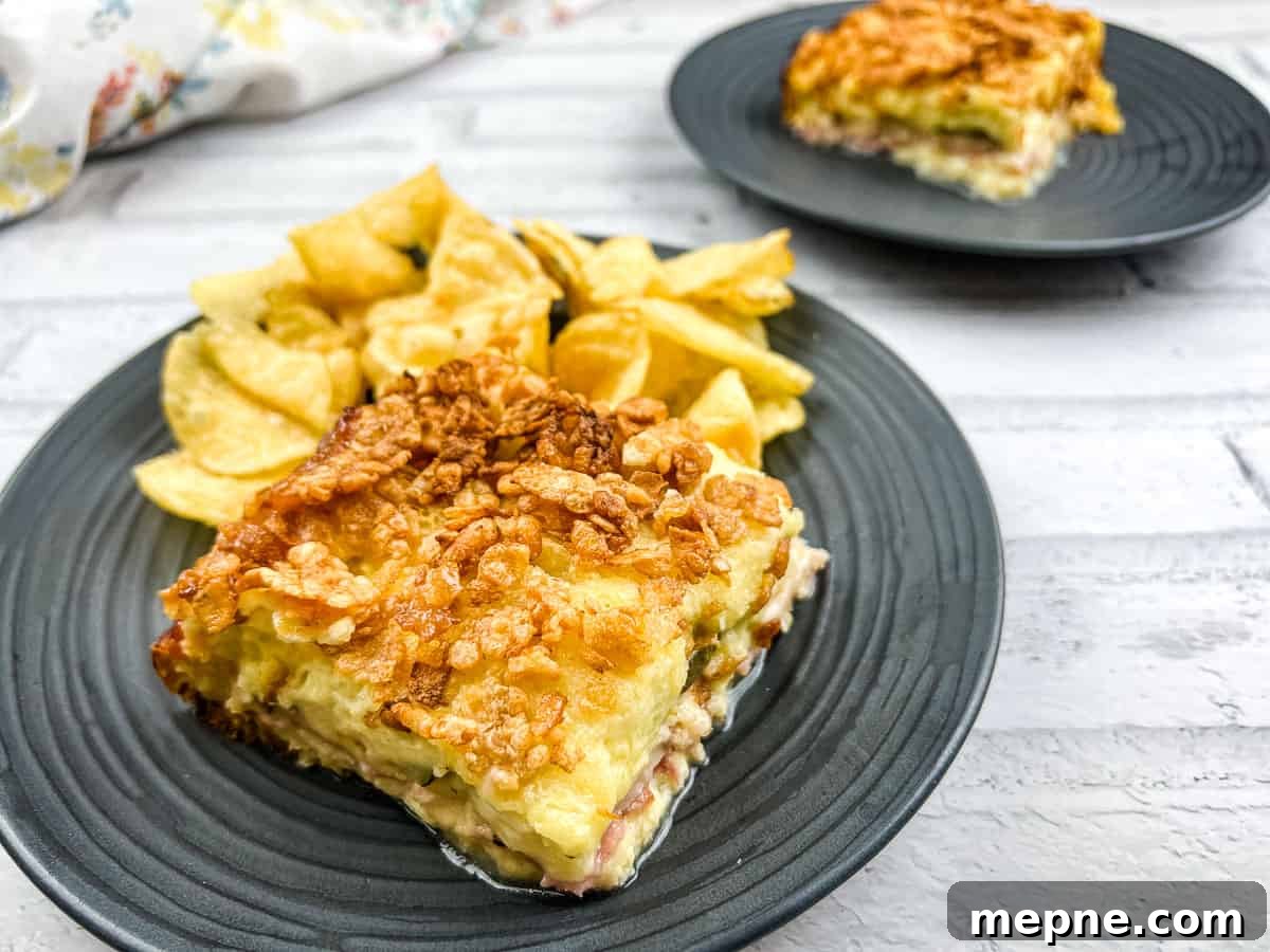 35 Classic Casserole Recipes That Have Everyone Coming Back 30 A piece of Cuban sandwich casserole on a plate with potato chips.