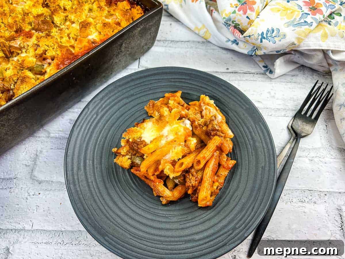 35 Classic Casserole Recipes That Have Everyone Coming Back 32 A serving of Sloppy Joe Casserole pasta with meat on a plate with a fork.