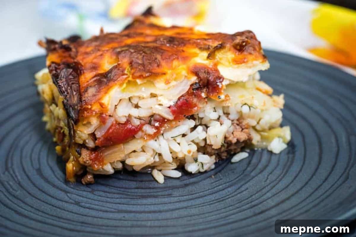35 Classic Casserole Recipes That Have Everyone Coming Back 34 A slice of layered cabbage roll casserole served on a dark plate.