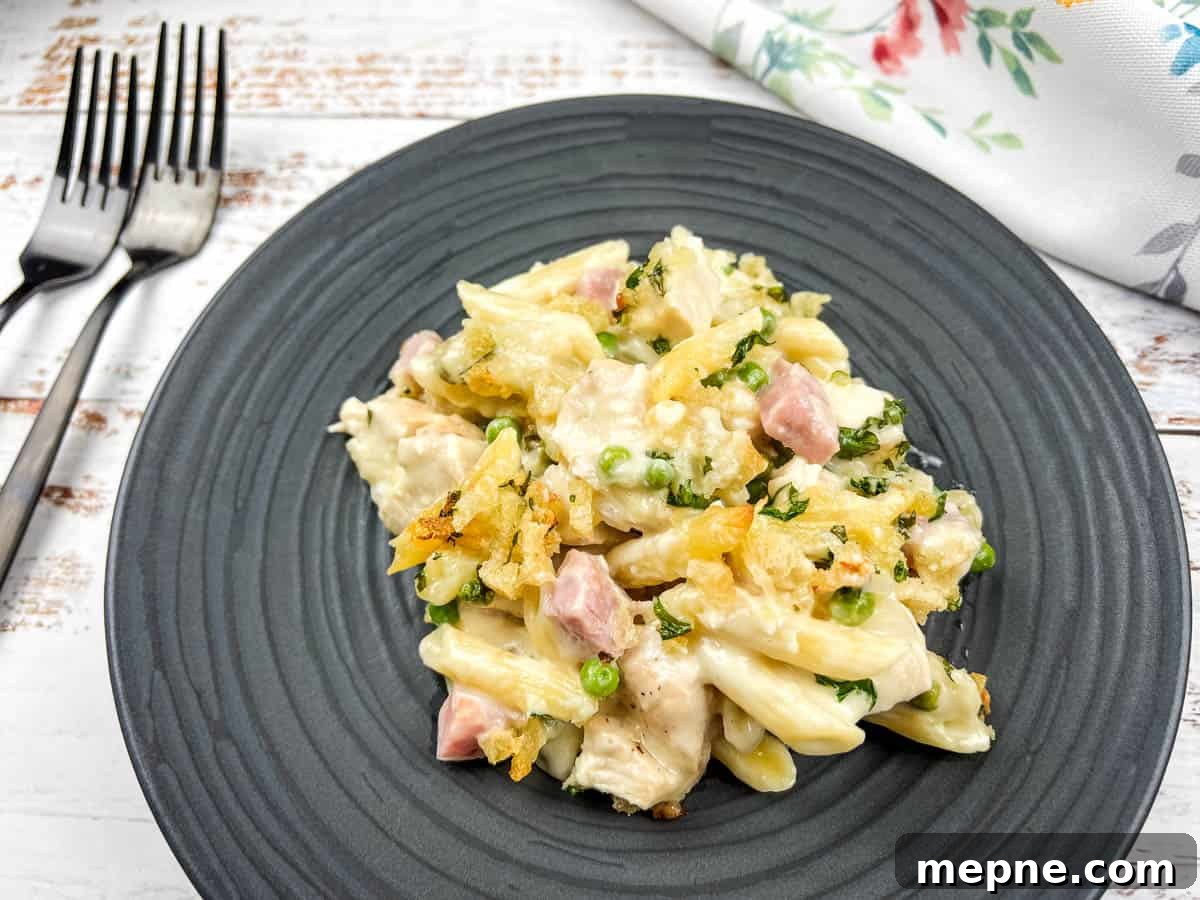35 Classic Casserole Recipes That Have Everyone Coming Back 9 Chicken cordon bleu casserole on a black plate with a fork.