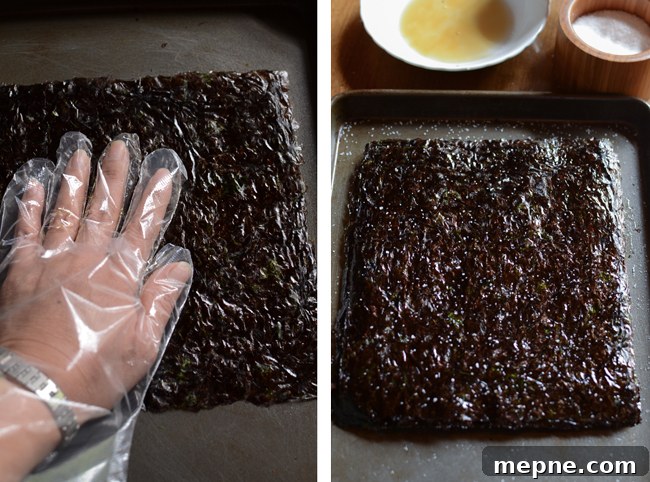 How to Make Crispy Roasted Seaweed Snacks at Home 5 A hand with plastic glove is rubbing the oil to the seaweed sheets