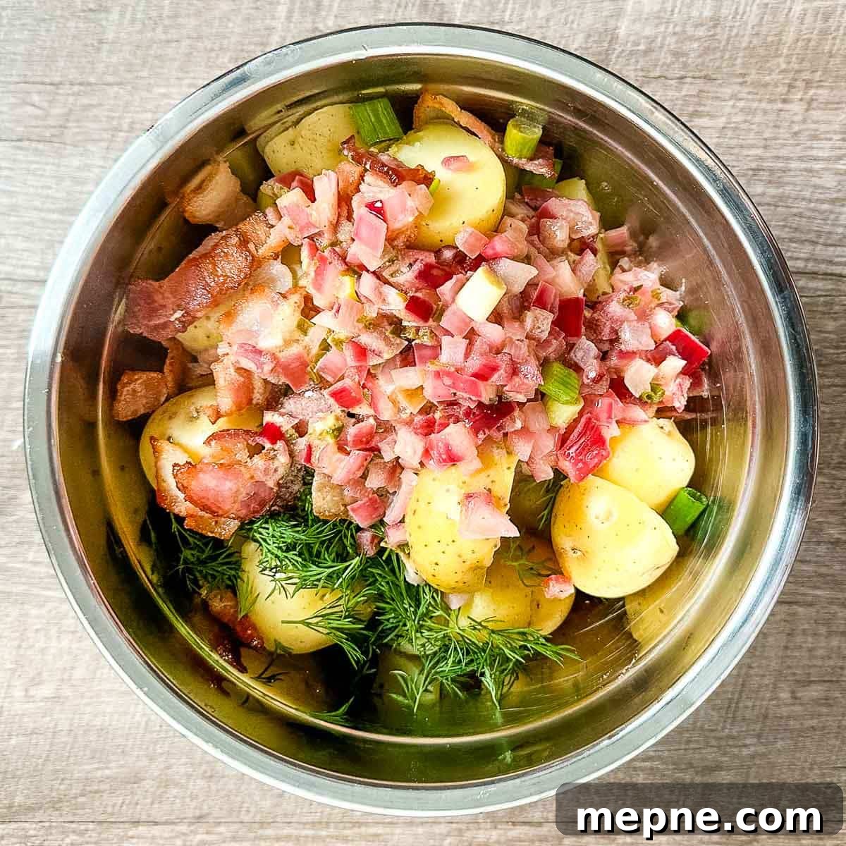 Authentic Bavarian Potato Salad with Bacon Recipe 15 all of the ingredients for bavarian potato salad in a stainless steel bowl.