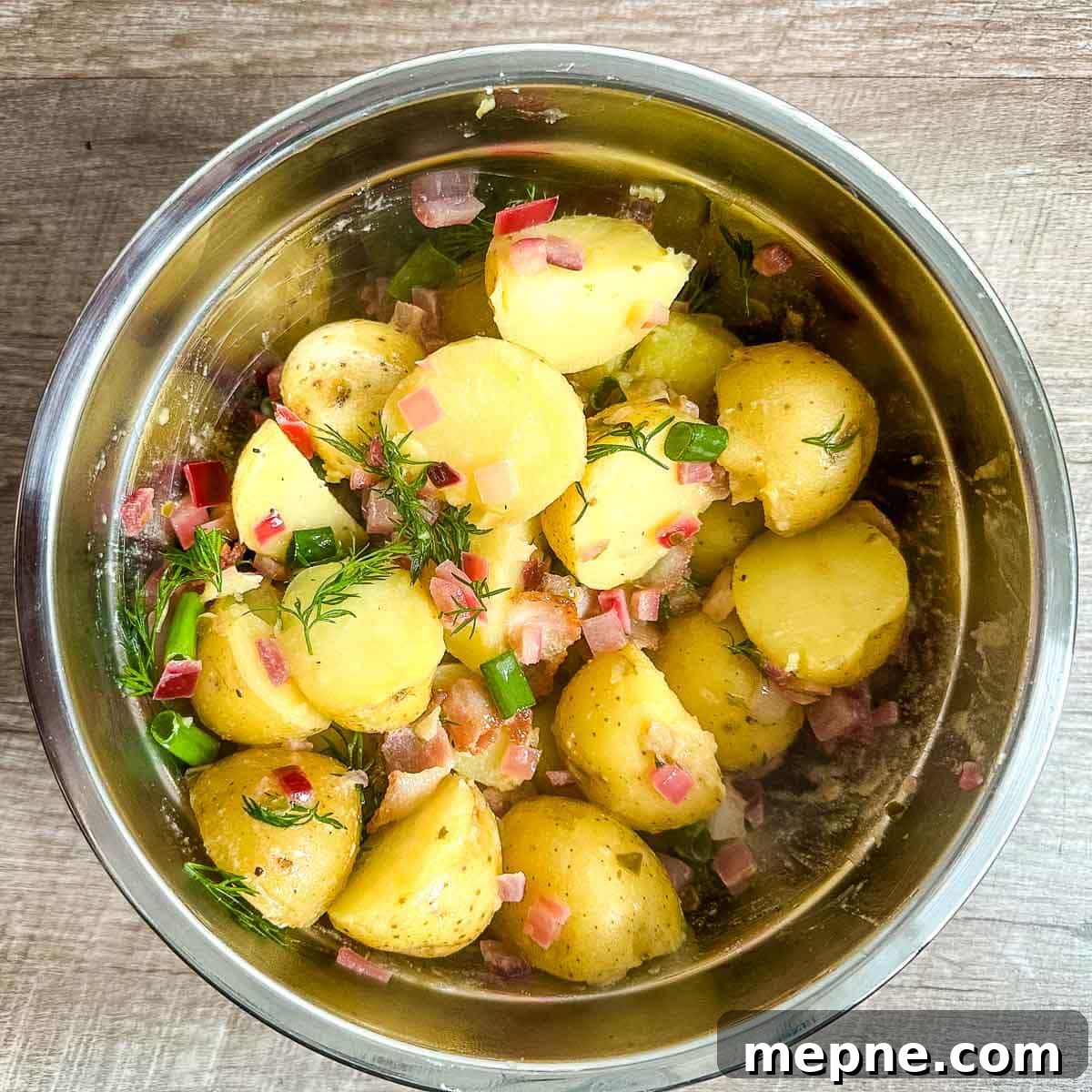 Authentic Bavarian Potato Salad with Bacon Recipe 16 finished bavarian potato salad in a stainless steel bowl.