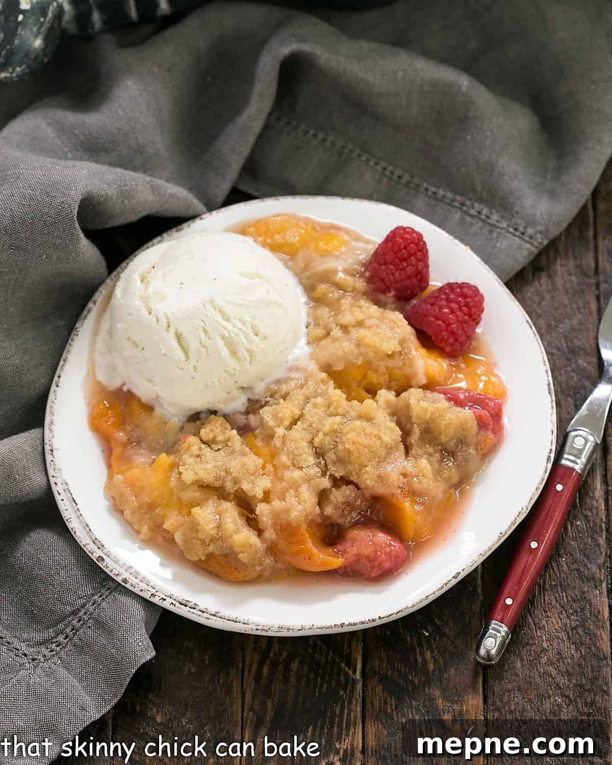 Peach Raspberry Crisp Recipe with Crunchy Oat Topping 3 Overhead view of peach raspberry crisp topped with a scoop of ice cream.