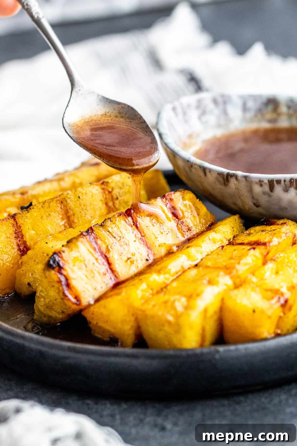 Cinnamon sauce being drizzled on cooked pineapple.