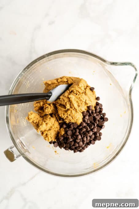 Fold in the chocolate chips. Glass mixing bowl with cookie dough and chocolate chips