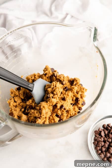 Divide and chill the dough. Cookie dough being mixed in glass bowl with spatula