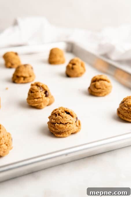 Scoop the dough, chill, and bake. Cookie dough balls on parchment-lined baking sheet