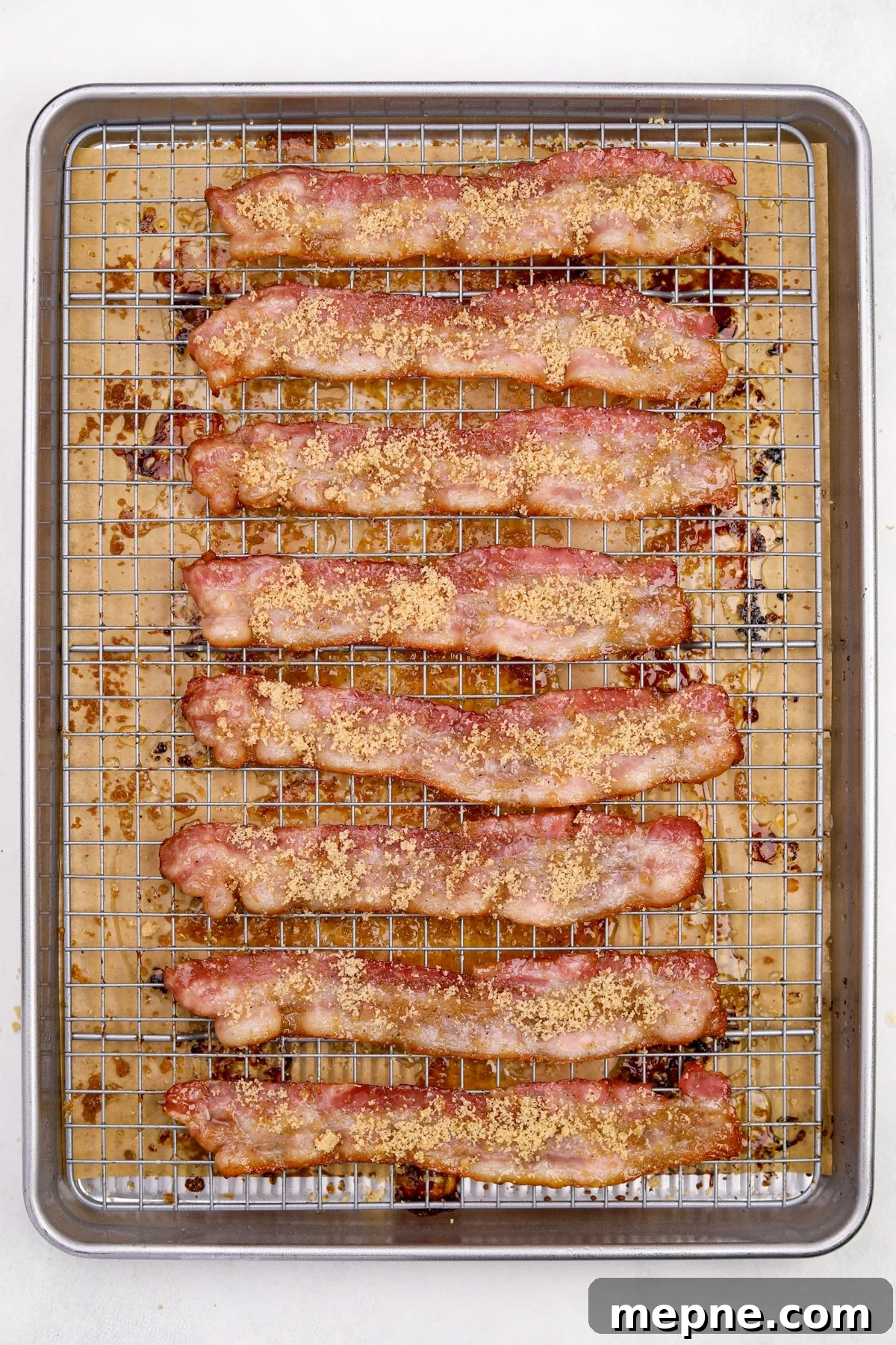 How to Make Candied Bacon: Sweet and Smoky Recipe 8 Half cooked bacons strips being topped with brown sugar.