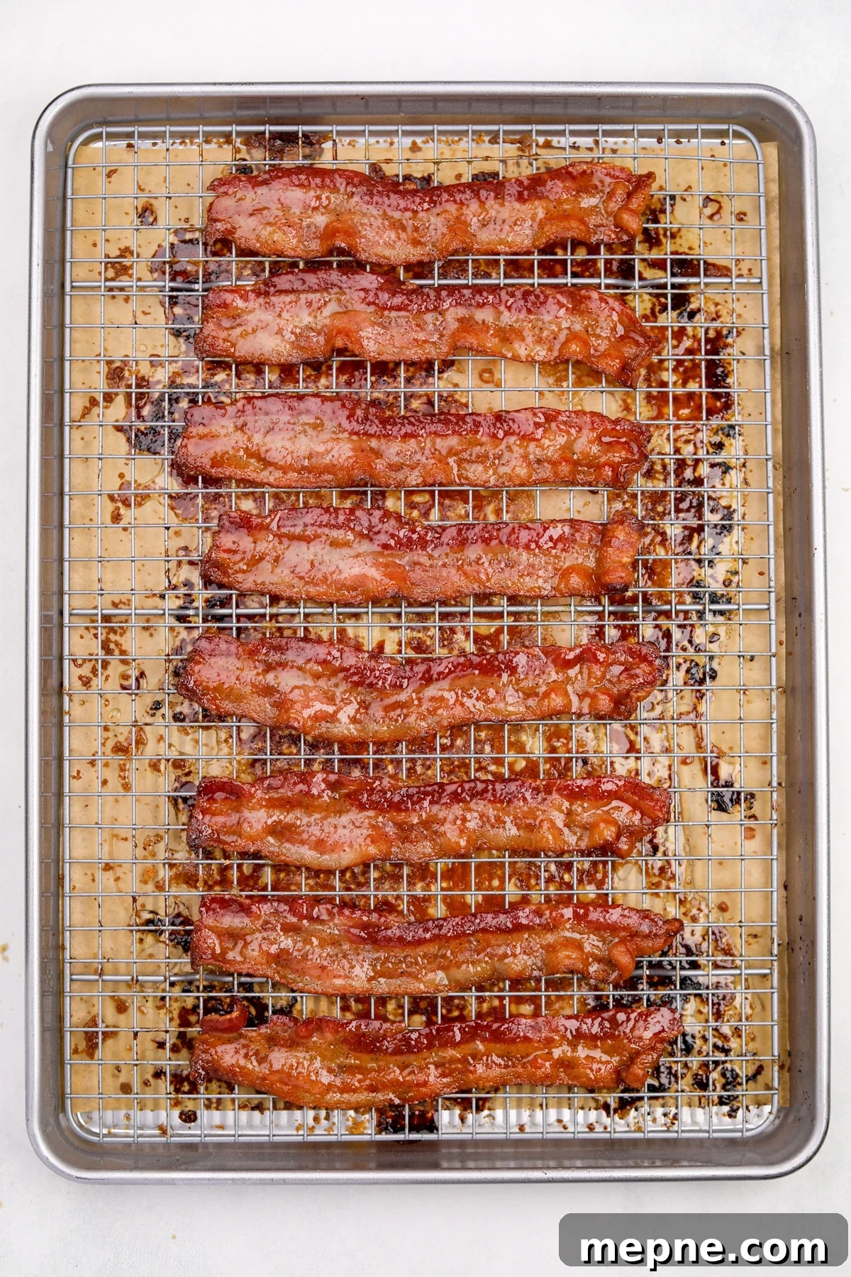 How to Make Candied Bacon: Sweet and Smoky Recipe 9 Crispy cooked bacon on a wire rack set inside of a baking sheet.