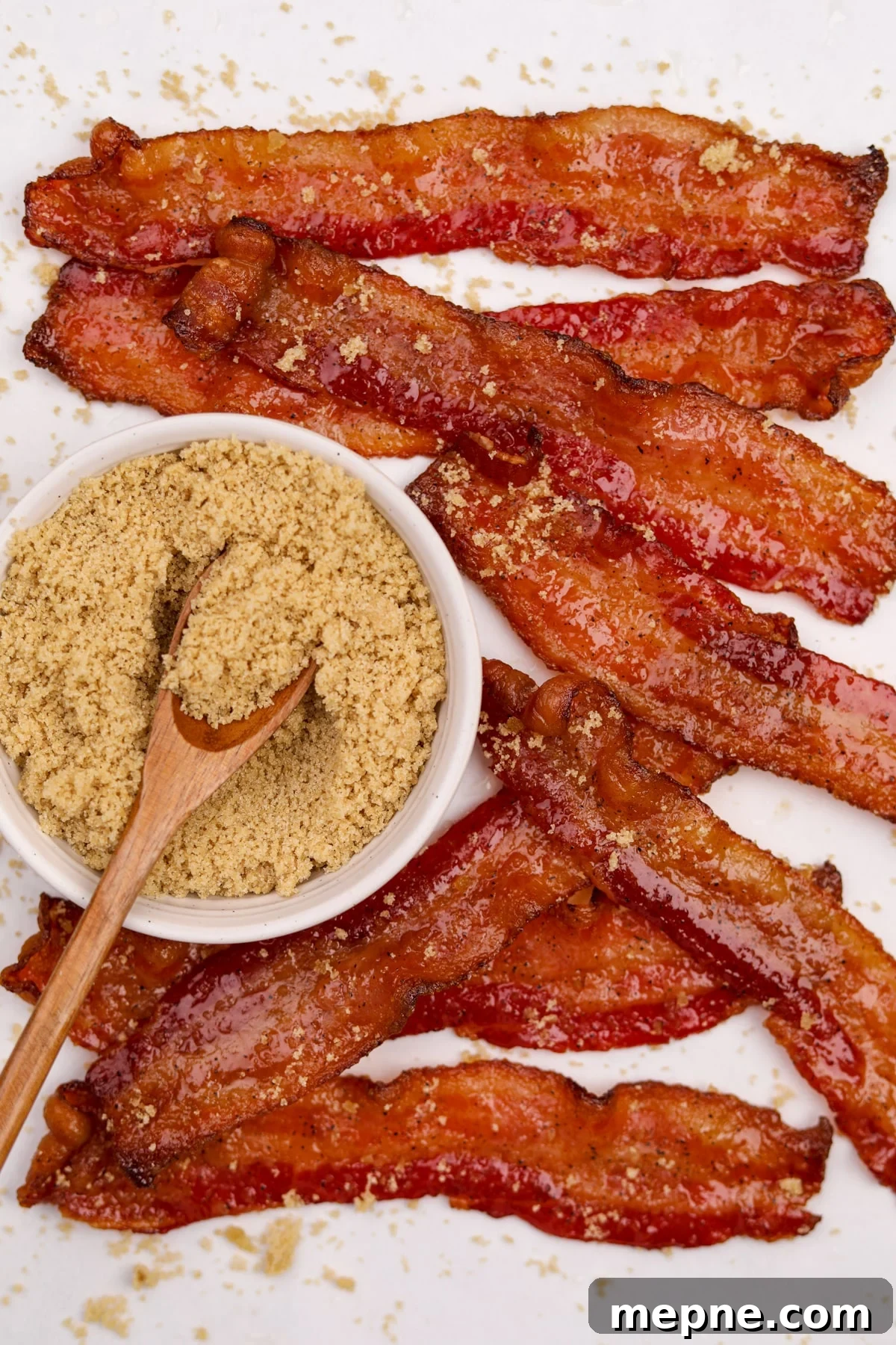 How to Make Candied Bacon: Sweet and Smoky Recipe 10 A small bowl of brown sugar surrounded by candied bacon strips.