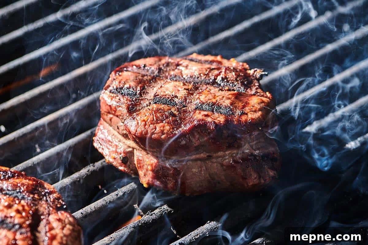 How to Get Perfect Crosshatch Grill Marks on Steak 2 Cooked filet mignon steaks with cross-hatch grill marks on cutting board.