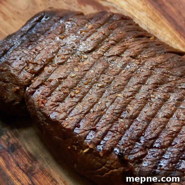 How to Get Perfect Crosshatch Grill Marks on Steak 4 Grilled Marinated London Broil resting on a wooden surface.