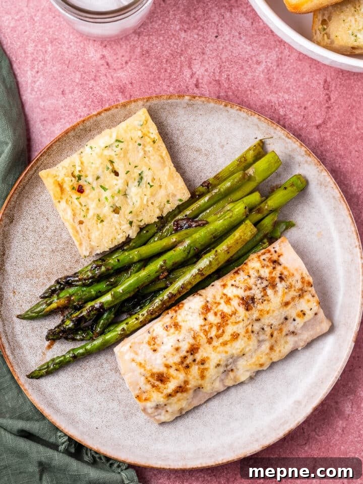 Broiled Mahi Mahi with Parmesan Butter Crust 3 Gray plate with garlic bread, asparagus and broiled mahi mahi fillet