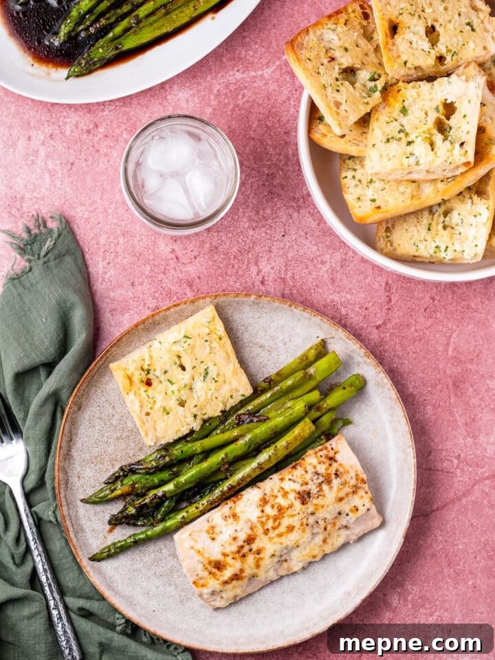 Broiled Mahi Mahi with Parmesan Butter Crust 9 Fish, asparagus and bread on a plate, fork and napkin, jar of ice water and basket of bread