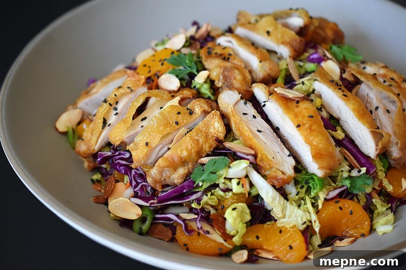Whole30 Chinese Chicken Salad Gluten Free 12 A close up of Whole30-friendly Chinese Chicken Salad, a colorful blend of cabbage, carrots, mandarin oranges, herbs, and crispy Cracklin' Chicken.