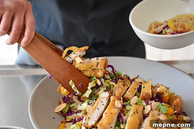 Whole30 Chinese Chicken Salad Gluten Free 13 Using a pair of wooden tongs to transfer the paleo and Whole30-friendly Chinese Chicken Salad to a serving bowl. The best gluten-free Chinese Chicken Salad!