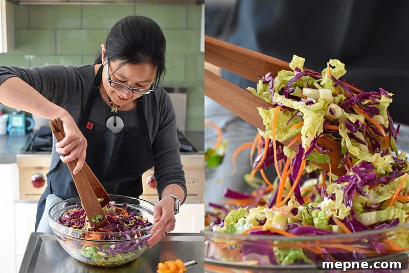Whole30 Chinese Chicken Salad Gluten Free 9 A woman is tossing Whole30-friendly Chinese Chicken Salad in a large clear bowl with wooden tongs.