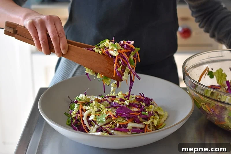 Whole30 Chinese Chicken Salad Gluten Free 10 Transferring the Whole30 Chinese Chicken Salad to a large grey ceramic serving platter.