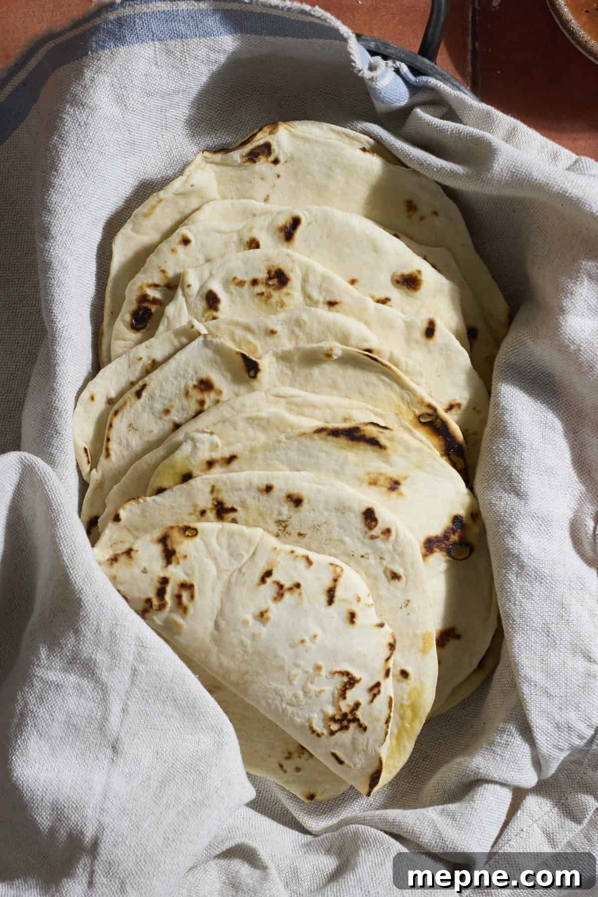 How to Make Sourdough Discard Tortillas 7 Sourdough Discard Tortillas wrapped in a kitchen towel.