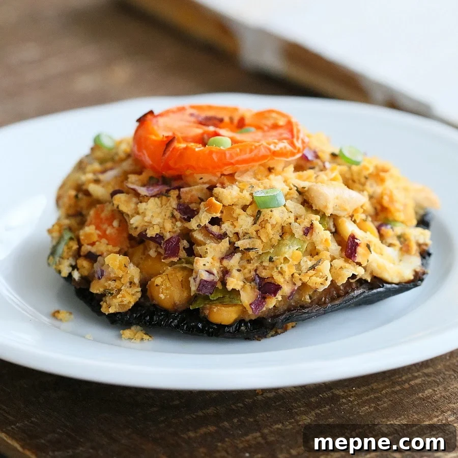 stuffed Portobello mushroom Side view of a vegan chickpea stuffed portobello mushroom on a white plate