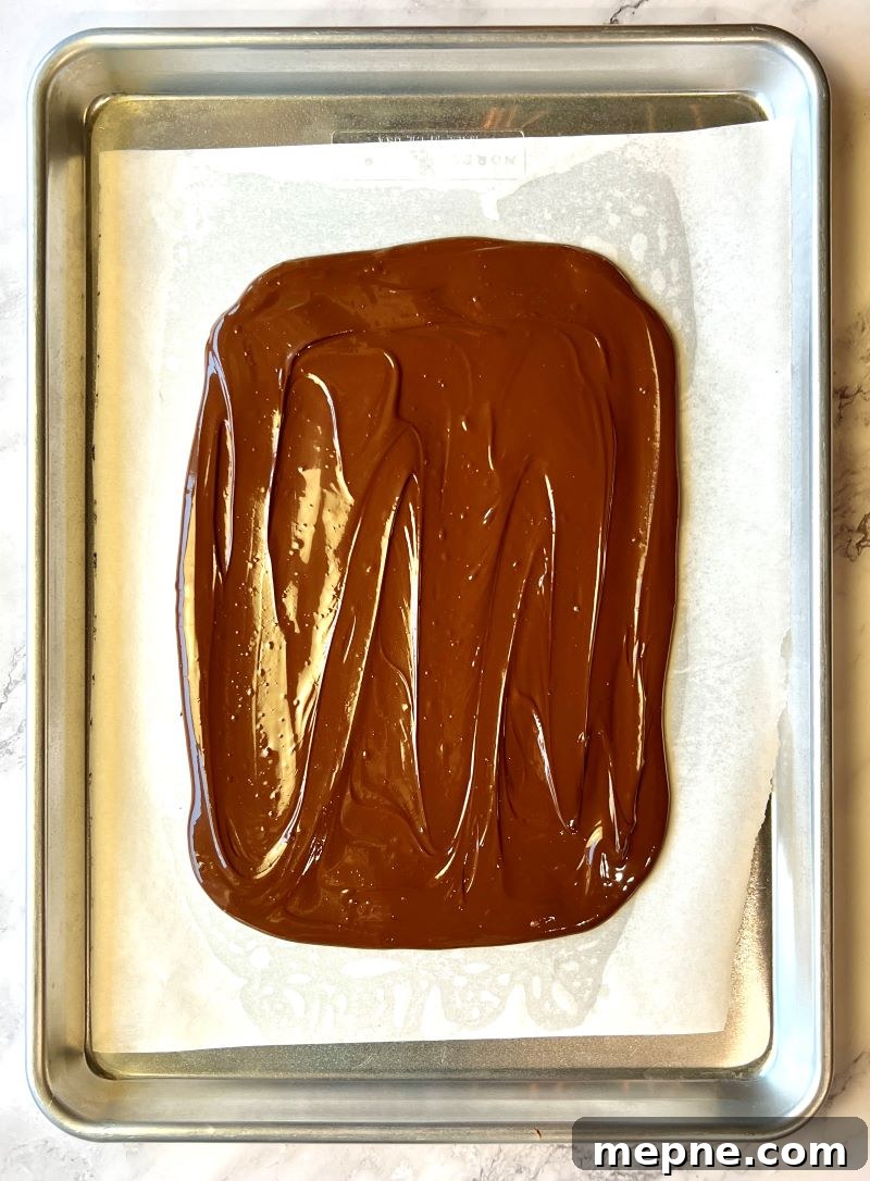 Cowboy Chocolate Christmas Bark Recipe 5 Melted chocolate spread out on sheet pan into a rectangle.
