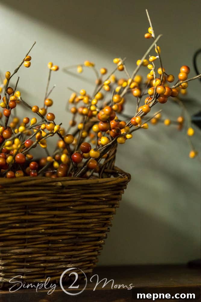 Square basket holding stems of orange and yellow fall berries to add fall color
