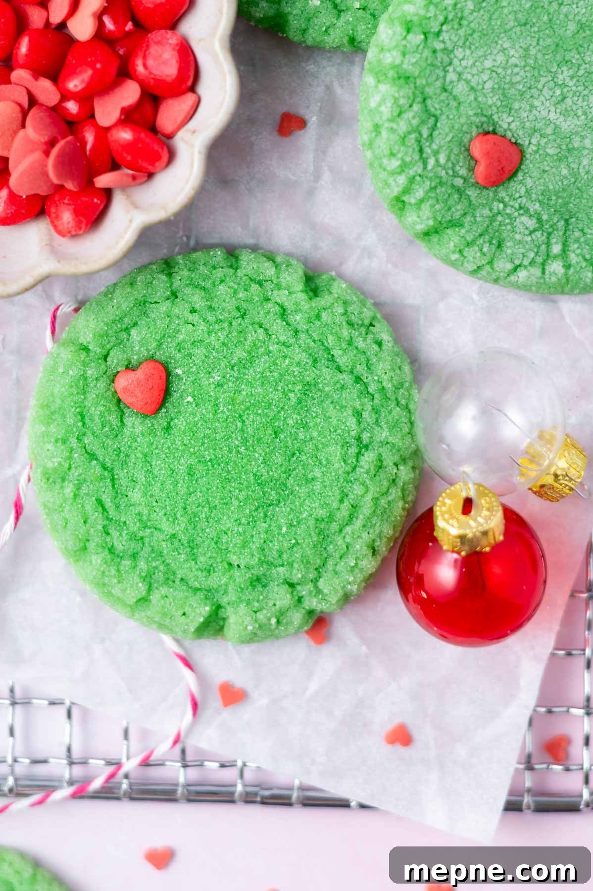 Soft Chewy Grinch Sugar Cookies for Christmas 11 round green grinch cookie with a red heart sprinkle