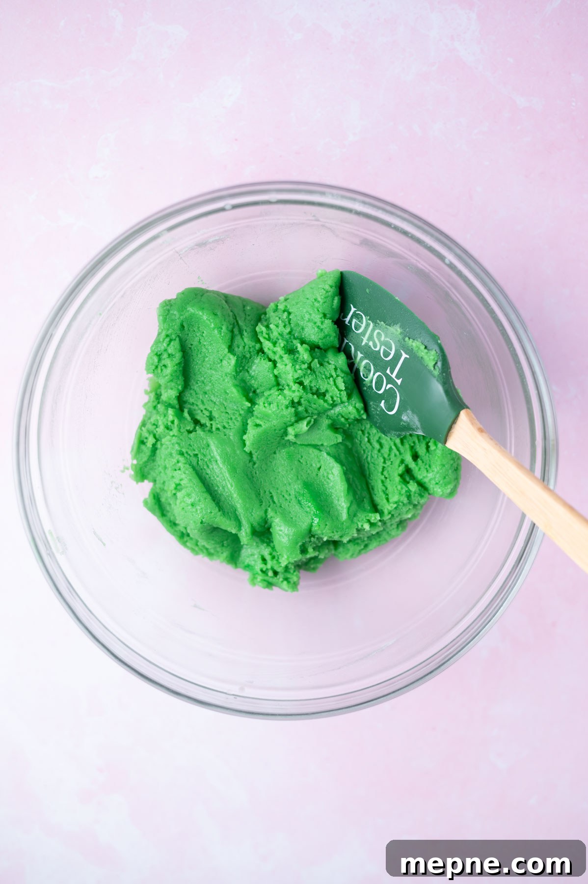 Soft Chewy Grinch Sugar Cookies for Christmas 7 green sugar cookie dough in a bowl with a spatula