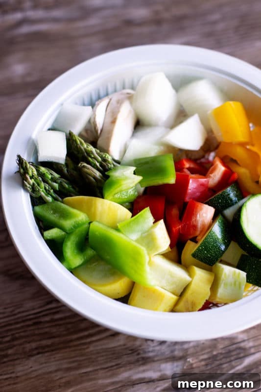 Crispy Oven Roasted Vegetables with Garlic and Herbs 5 Colander filled with fresh chopped vegetables, asparagus, peppers, onions, zucchini, squash and mushrooms.