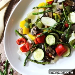Crispy Oven Roasted Vegetables with Garlic and Herbs 9 White platter containing oven roasted vegetable including asparagus, zucchini, squash, green peppers and onions.