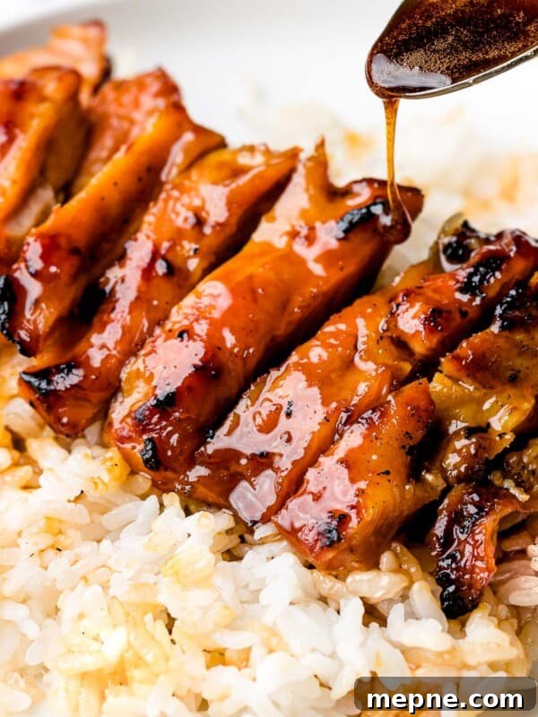 Chicken teriyaki glazed with sauce with steamed rice.