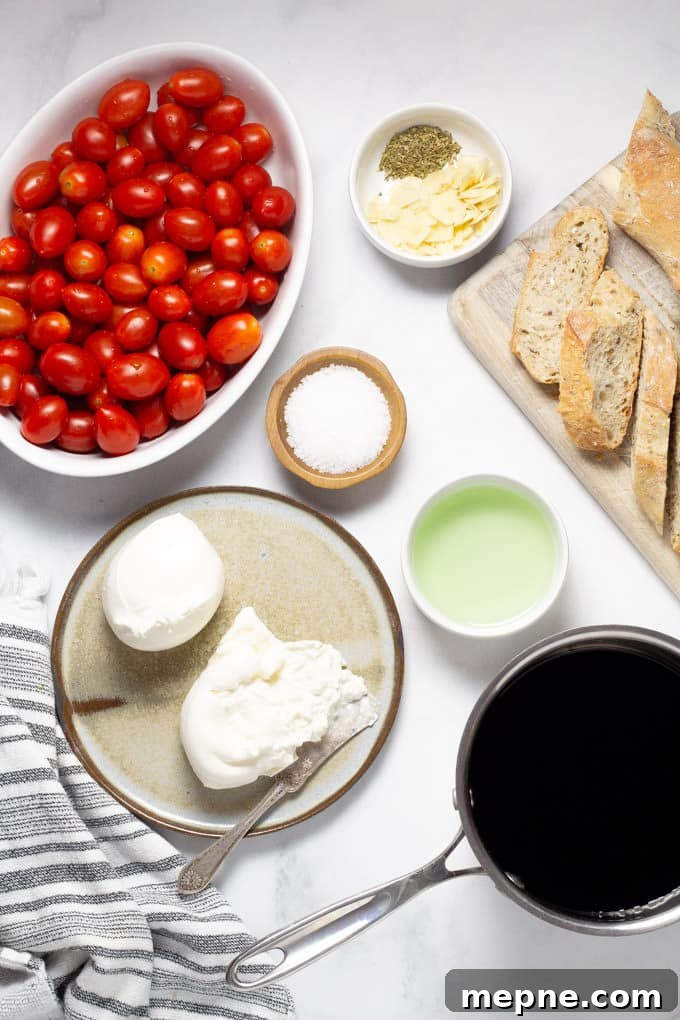 White marble counter top filled with the ingredients to make a roasted tomato appetizer