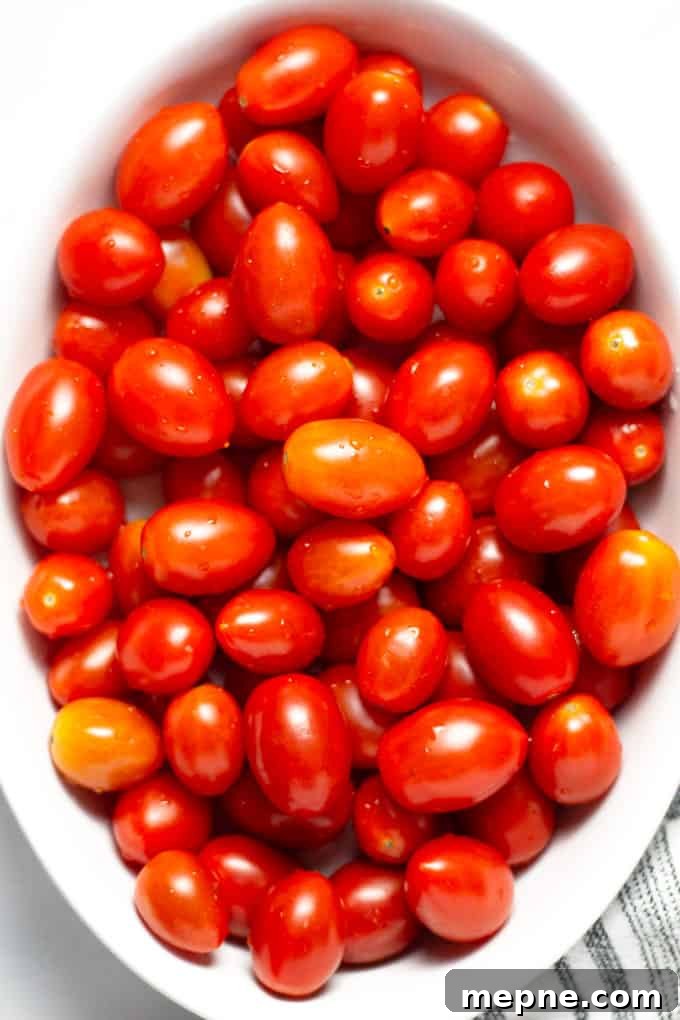 Close up overhead shot of a white platter filled with freshly washed grape tomatoes