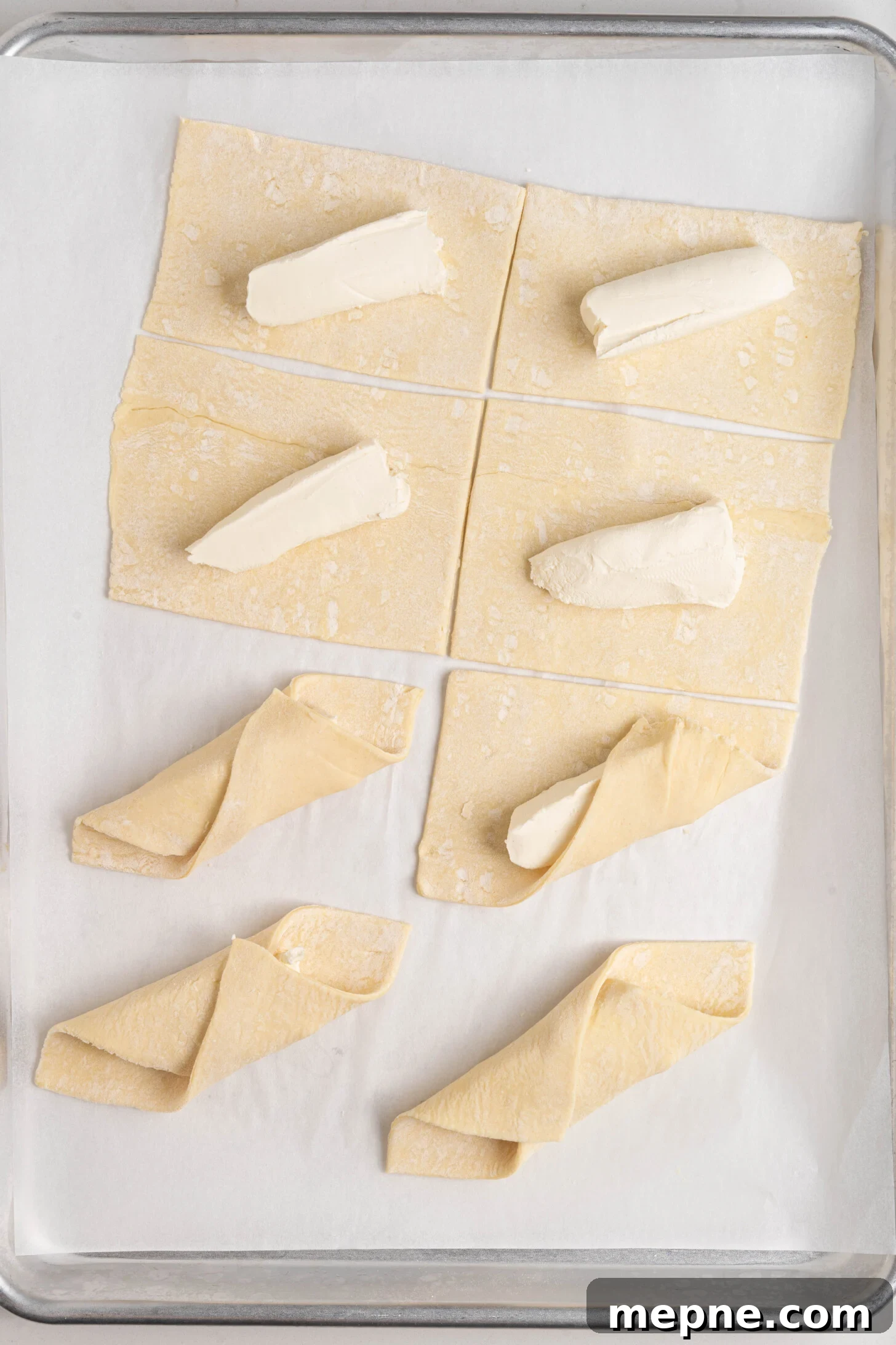 Authentic Puerto Rican Quesitos Recipe - Ready in 30 Minutes 6 Puff pastry and cream cheese being folded together.