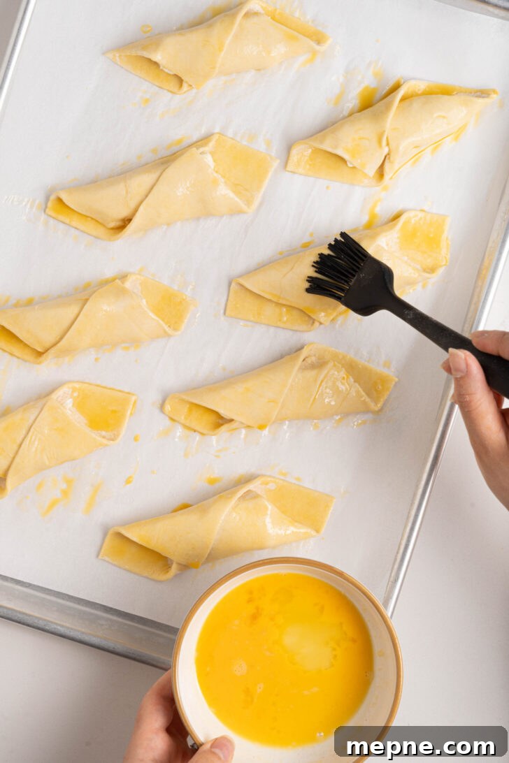 Authentic Puerto Rican Quesitos Recipe - Ready in 30 Minutes 7 Quesitos being brushed with egg wash.