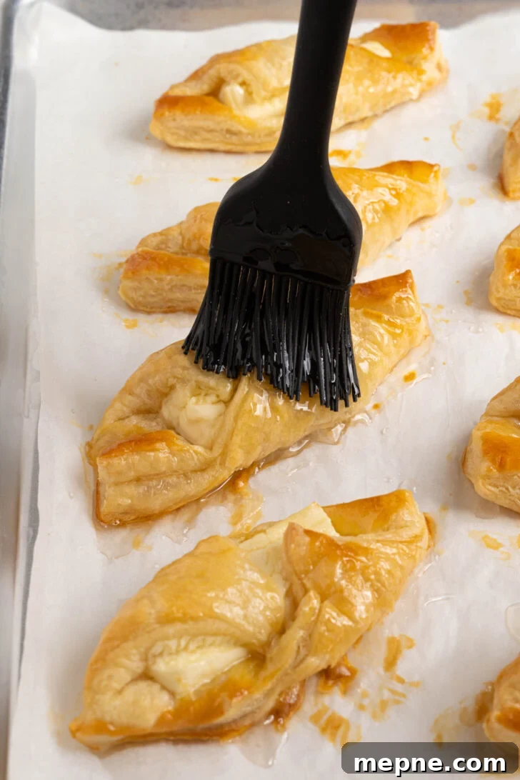 Authentic Puerto Rican Quesitos Recipe - Ready in 30 Minutes 8 Quesitos being brushed with simple syrup.