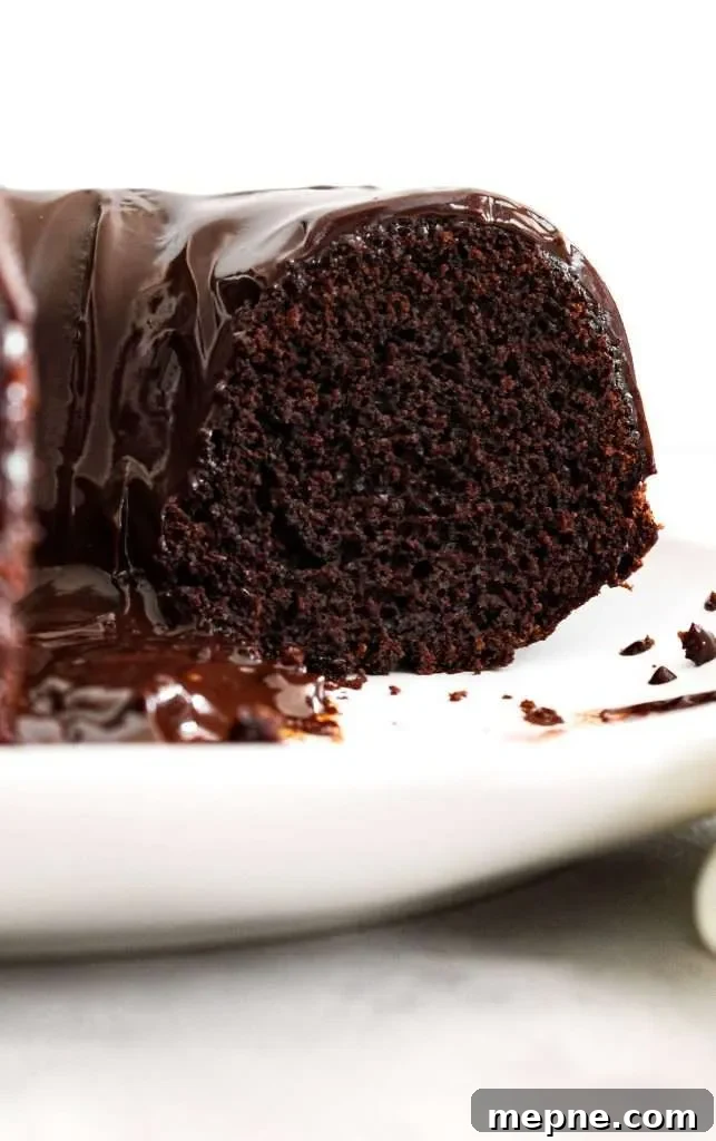 Rich Chocolate Bundt Cake with Silky Ganache Recipe 2 chocolate bundt cake topped with chocolate ganache inside slice view