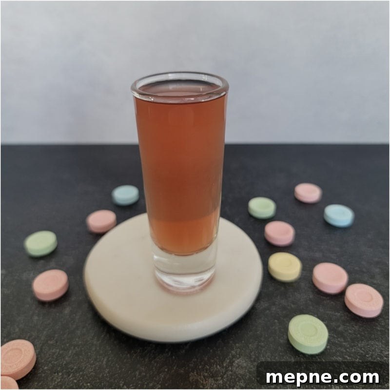 Chambord Cocktails: Raspberry Liqueur Recipes and Serving Tips 6 Sweet tart shot in a glass shot glass on a white coaster surrounded by Sweet Tart Candies