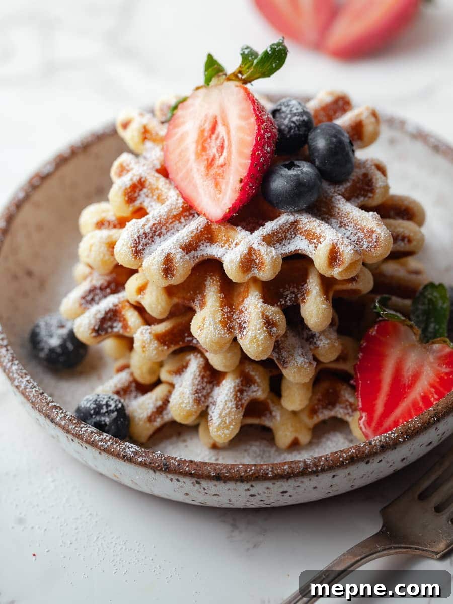 Crispy Gluten Free Waffles Recipe 8 close up of sour cream waffles, gluten free waffles topped with powdered sugar and fresh berries