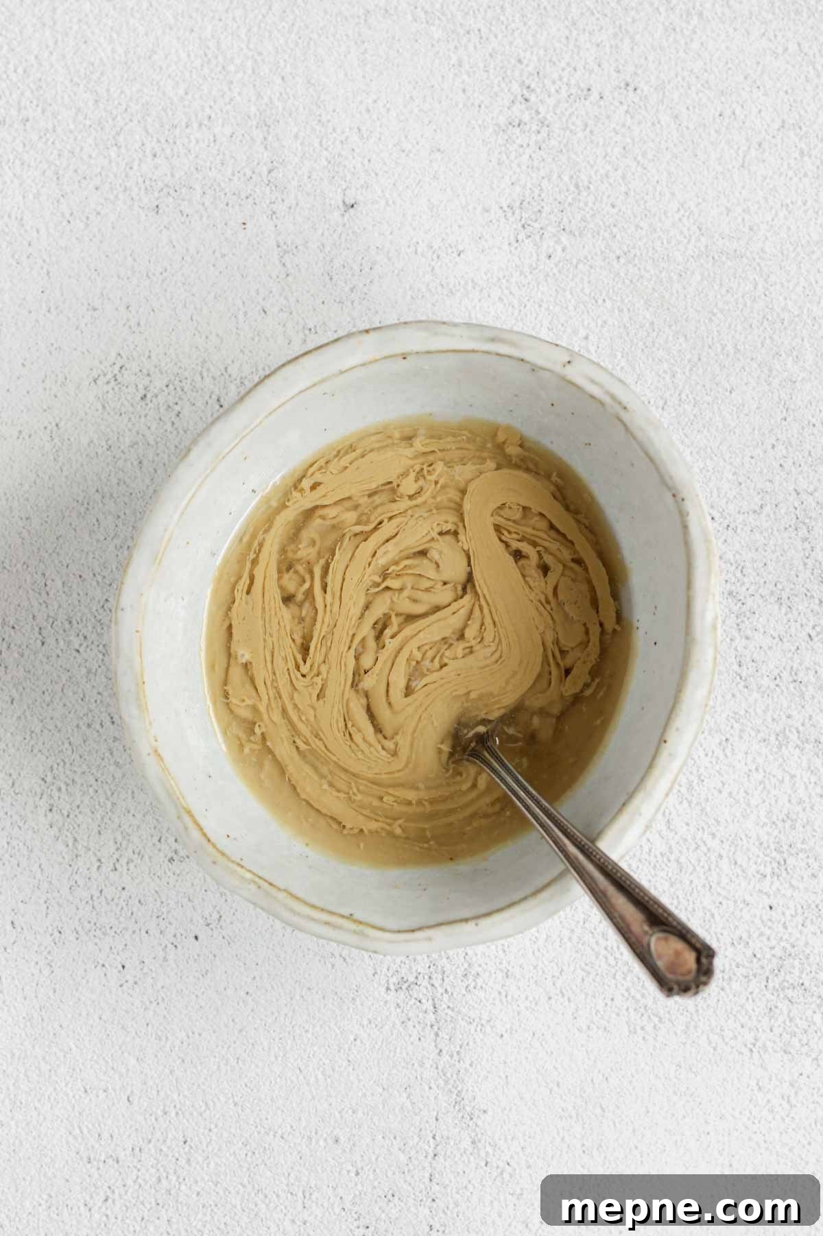 Creamy Maple Tahini Dressing for Salads and Grain Bowls 5 Maple tahini dressing ingredients being mixed in a shallow bowl.