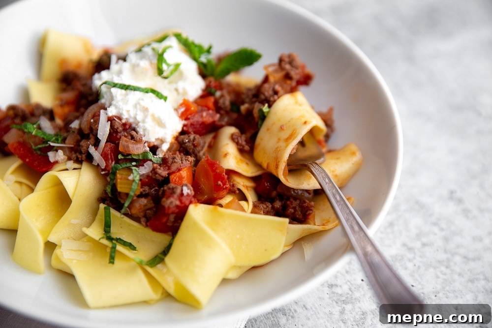 Weeknight Lamb Ragu with Fresh Mint and Ricotta 6 Close-up side angle showing pasta swirled around fork with ragu.