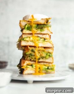 Avocado Grilled Cheese 3 sandwich halves stacked on each other on small marble plate