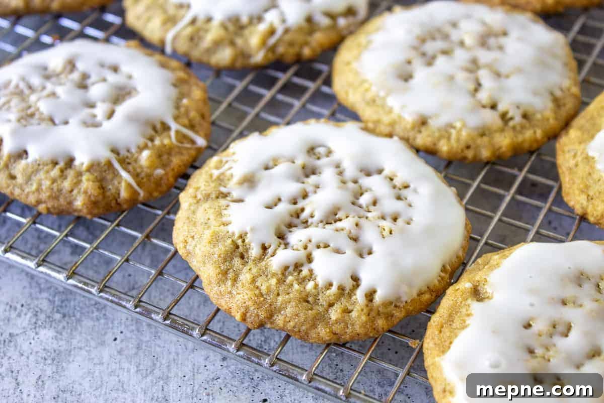 Old-Fashioned Iced Oatmeal Cookies Recipe 4 Iced oatmeal cookies on a baking rack.