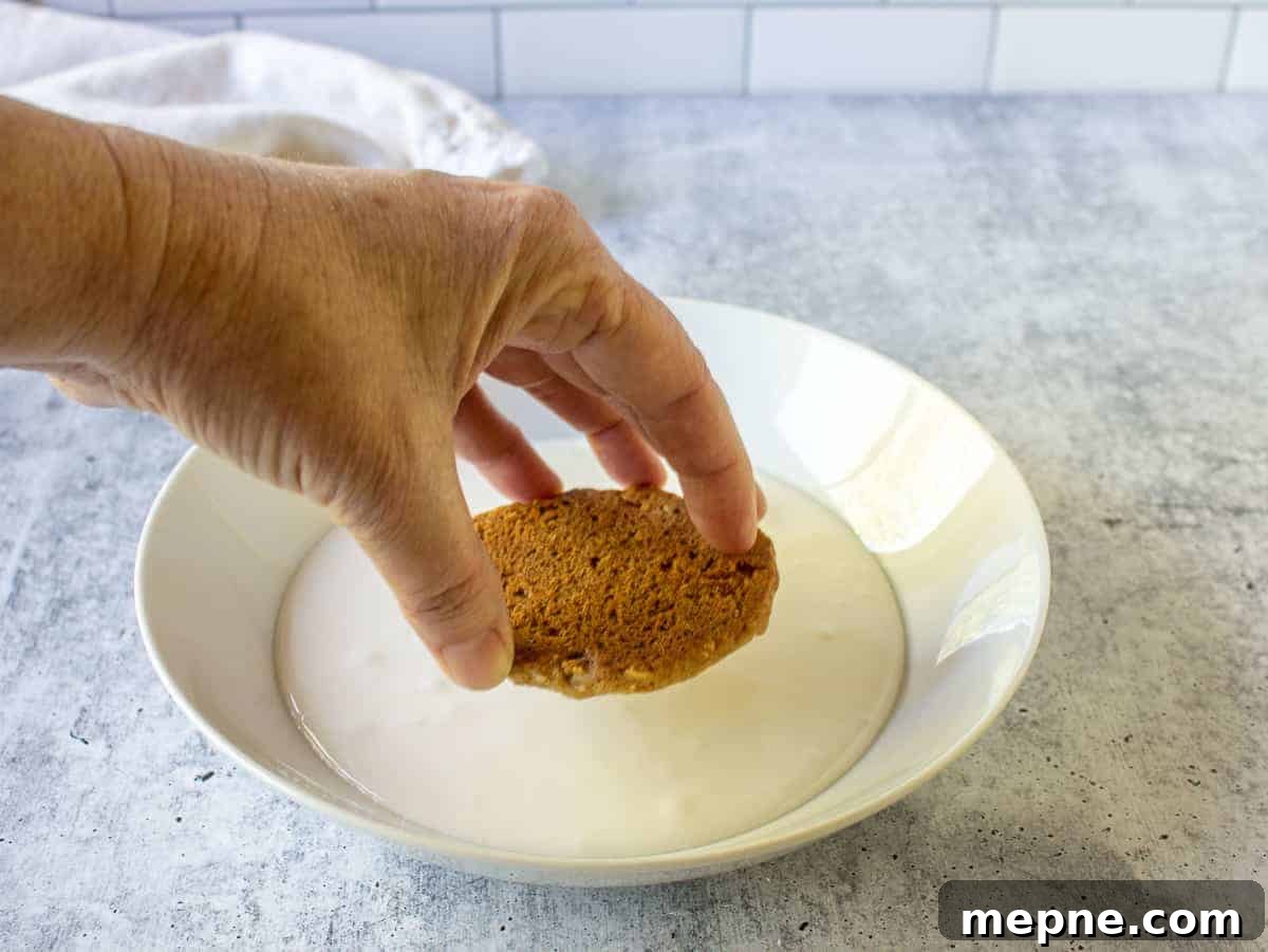 Old-Fashioned Iced Oatmeal Cookies Recipe 5 Dipping an oatmeal cookie into icing.