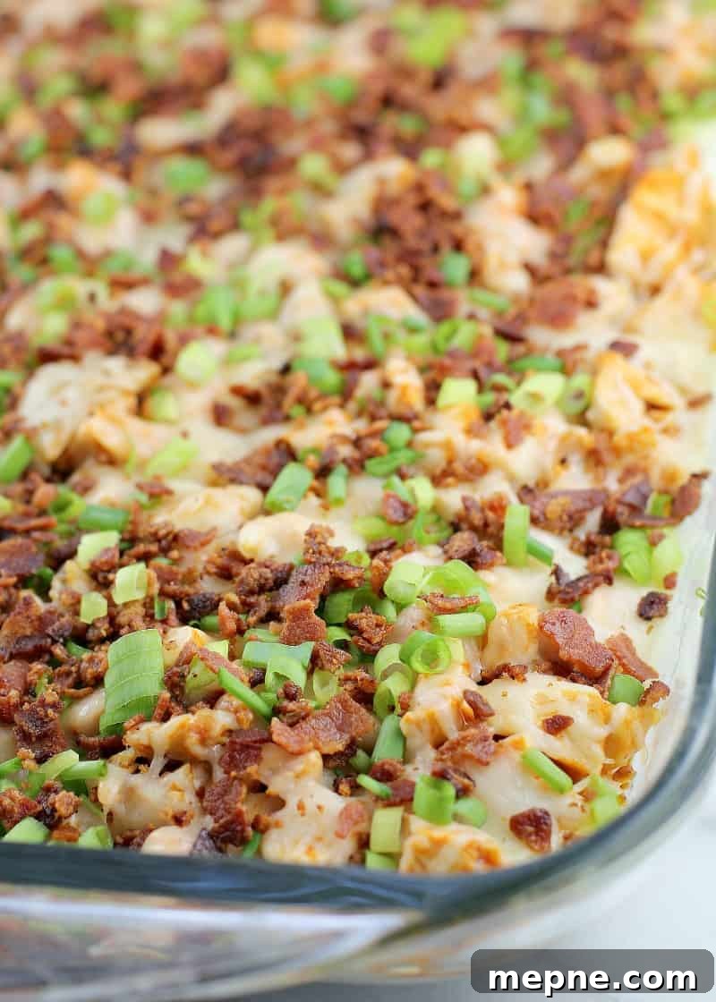 Cheesy Buffalo Chicken Dip with Bacon 3 top view showing the bacon and cheese on the rest of the dip in a clear glass bake dish