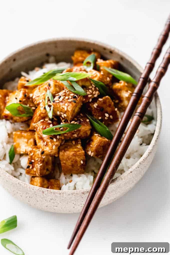 Crispy Baked Tofu with Teriyaki Glaze 2 teriyaki tofu in a ceramic bowl with wooden chopsticks