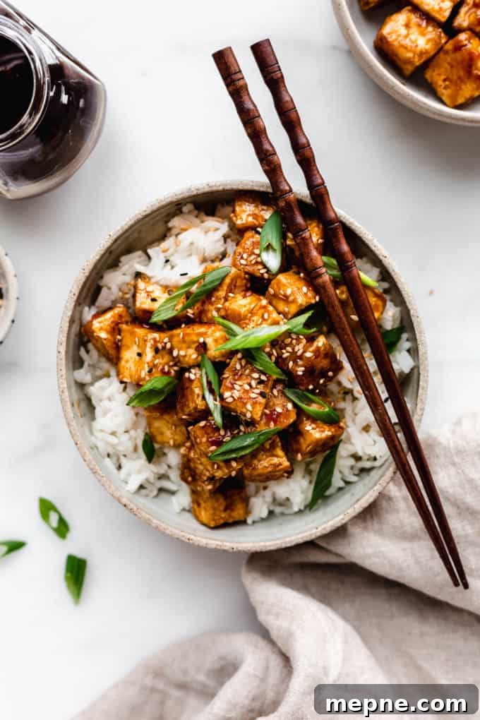 Crispy Baked Tofu with Teriyaki Glaze 7 A bowl of teriyaki tofu with a napkin on the side