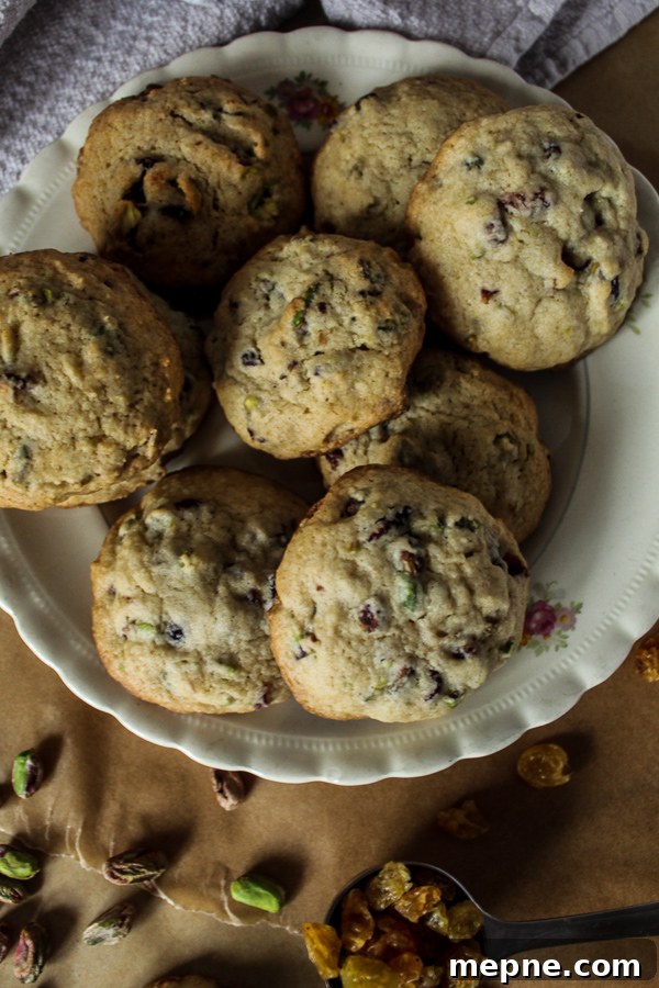Cranberry, Raisin and Pistachio Cookies Recipe 4 A white plate with cranberry raisin pistachio cookies on parchment